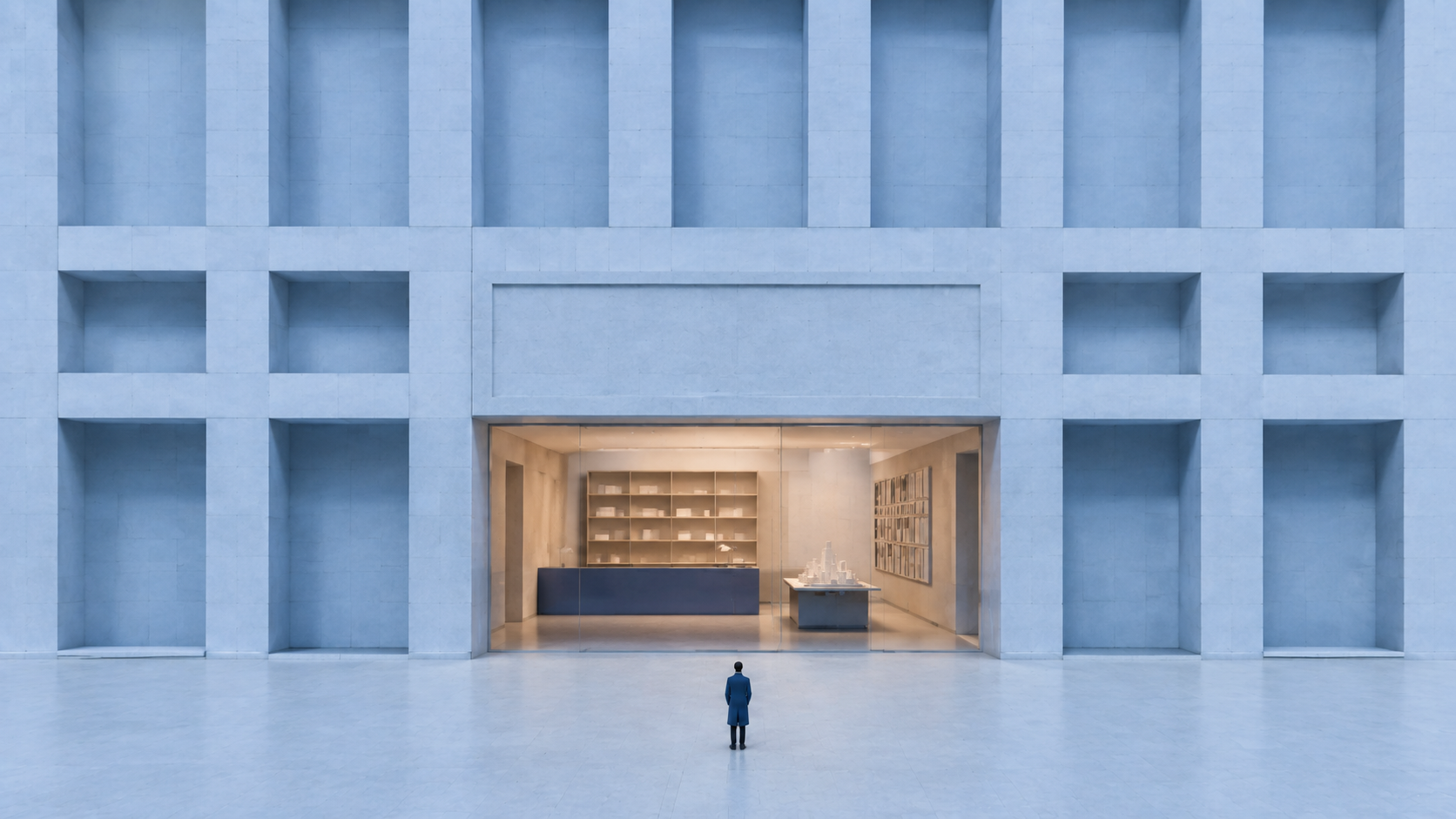 Blue architectural facade framing a warmly lit professional studio entrance